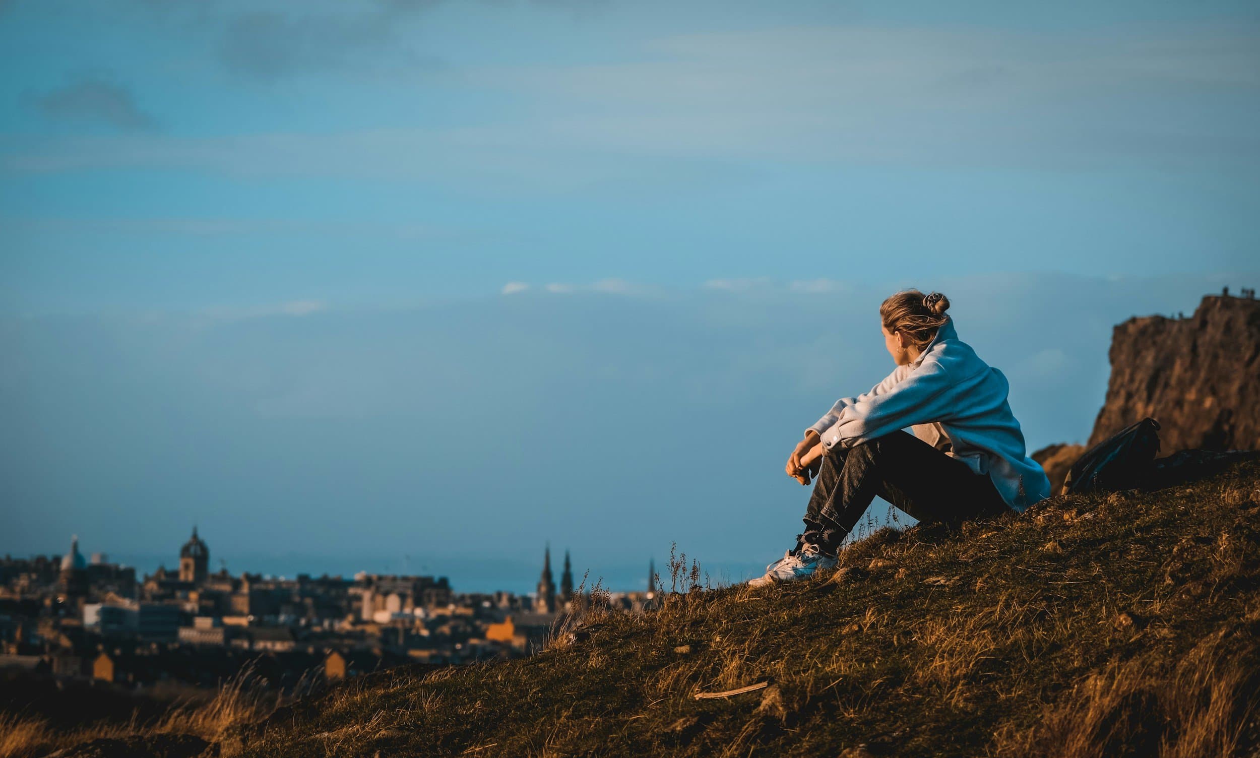 A young person taking quiet time outdoors above a city